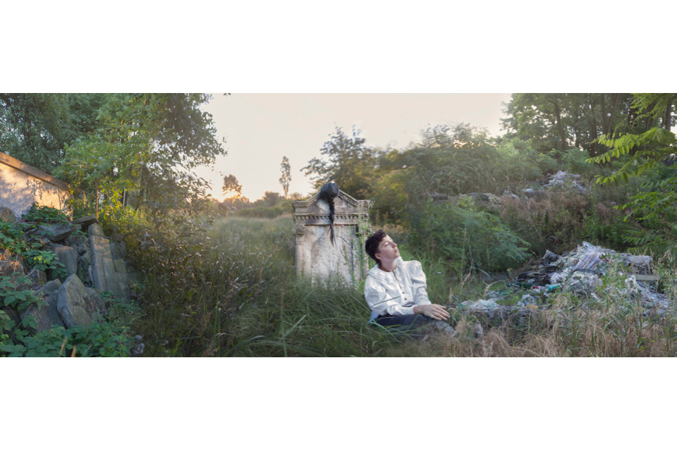 woman in old cemetery with trash pile on one side