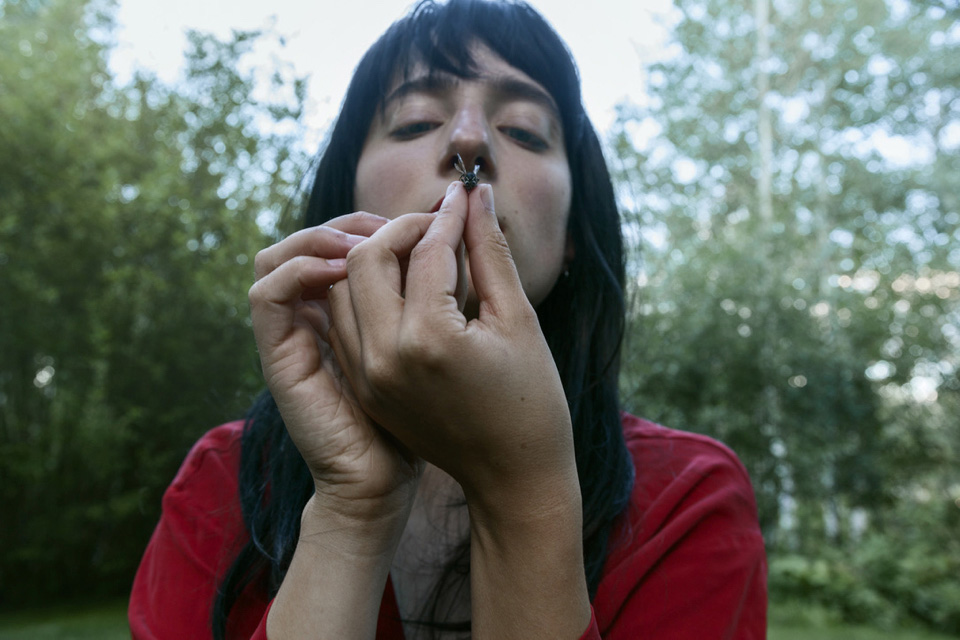 close up image of woman inspecting an insect