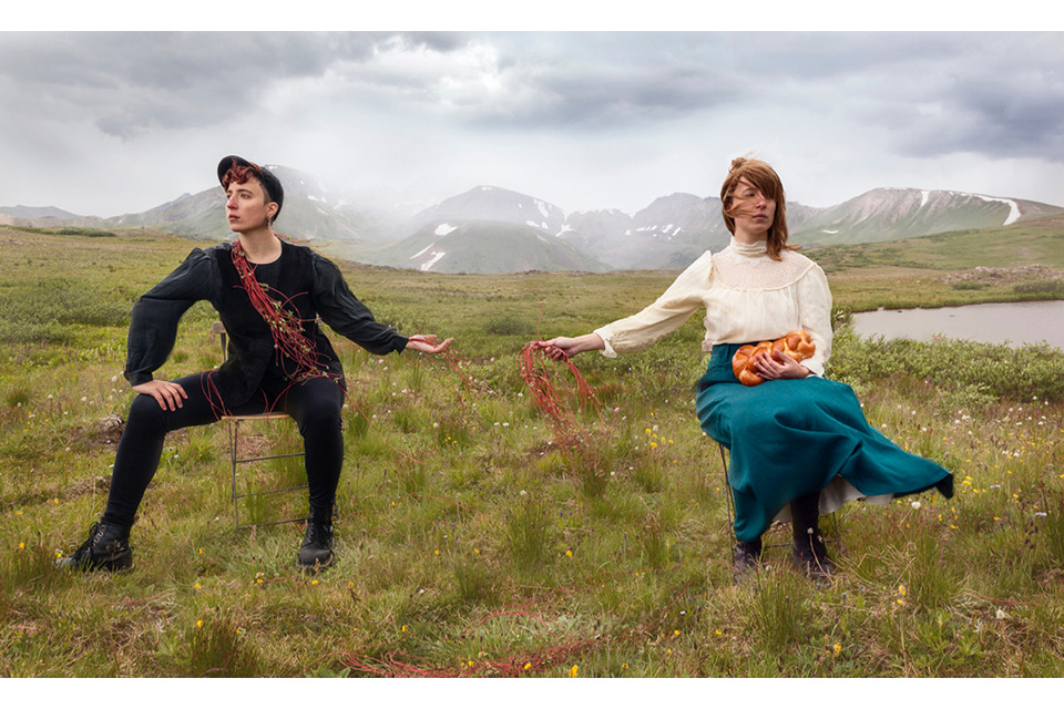 two women (Shterna Goldbloom) dressed differently holding hands in a field