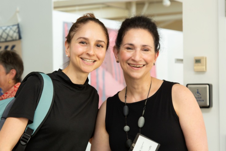 two women standing closely together smiling 