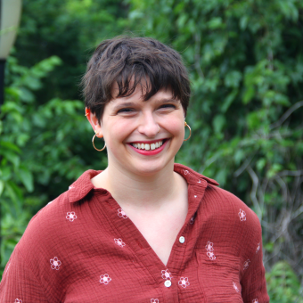 Avigayil Halpern, wearing a red shirt, with green trees in the background