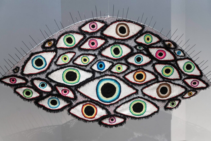 Image of stitched artwork: a large eye with many smaller eyes inside it