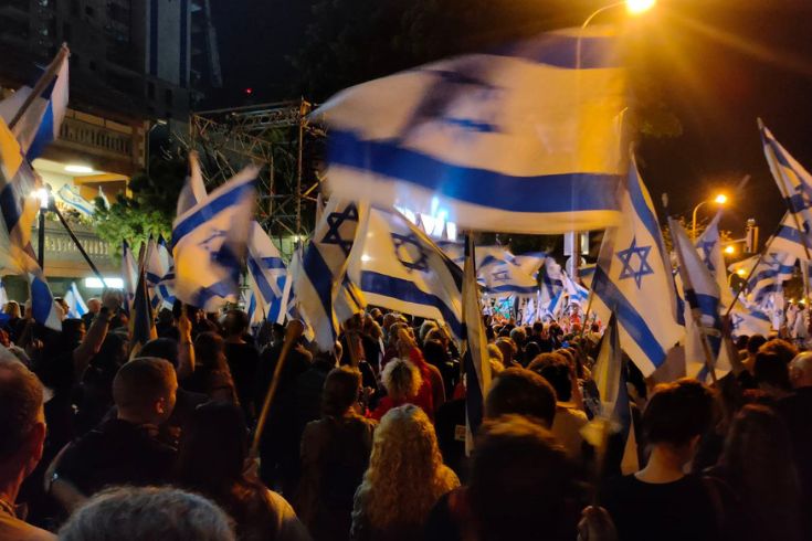 Israeli people protesting with flags at night