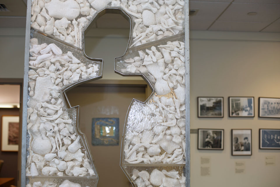 A sculpture with the cut-out silhouette of a woman surrounded by white rocks