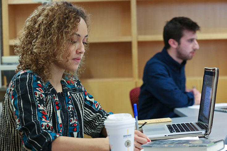 A graduate student takes notes in class