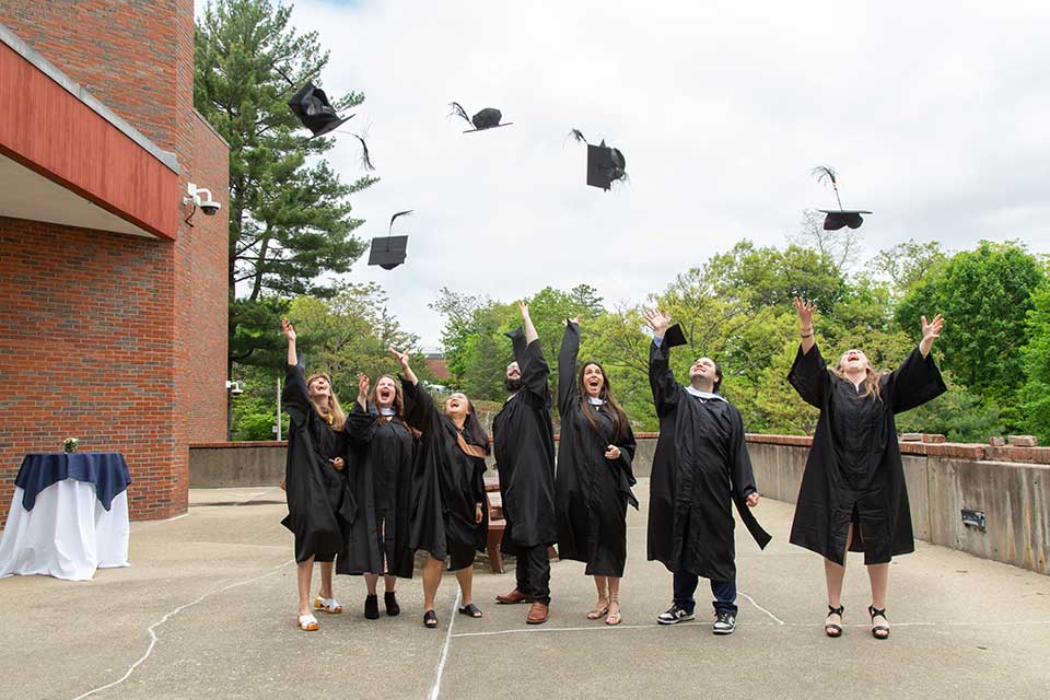 Graduates of the class of 2025 toss their caps into the air