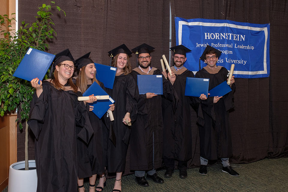 Class of 2019 Hornstein graduates smiling in caps and gowns