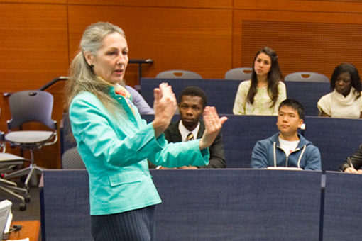female faculty members gestures while lecturing to students