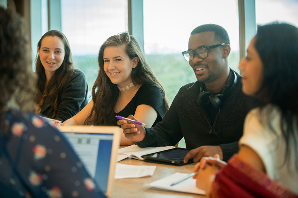 A small group of students laugh in a classroom