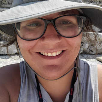 Headshot of Devon Derouen with a hat on, smiling