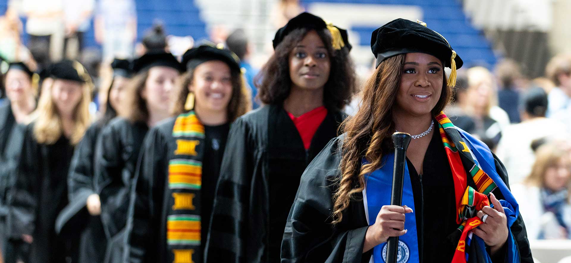 Graduates walk in Gosman Convocation Center