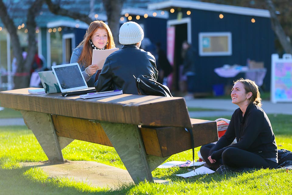 Three students sitting outside and talking