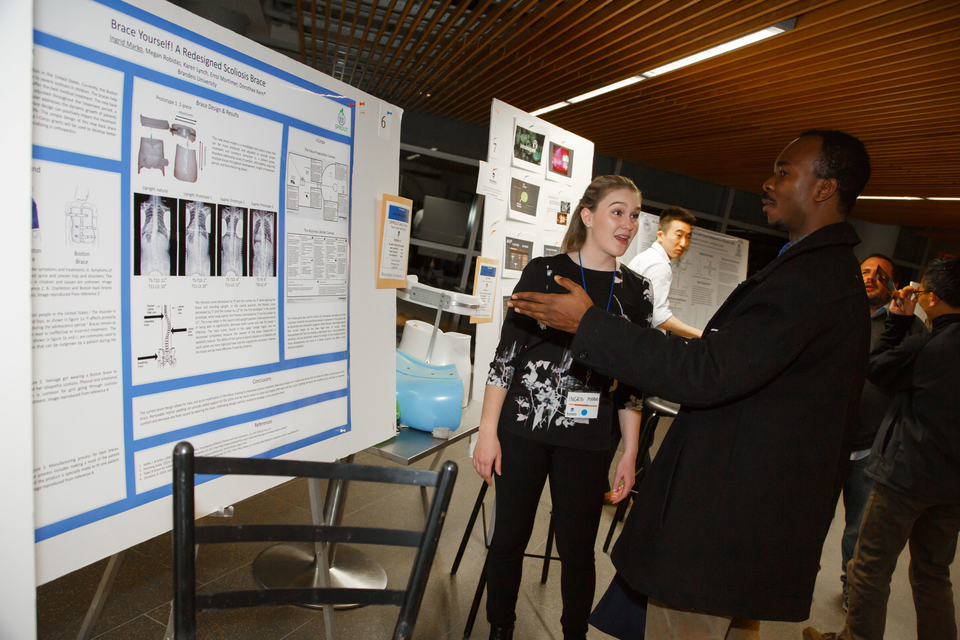 a woman explaining context from the poster to another man