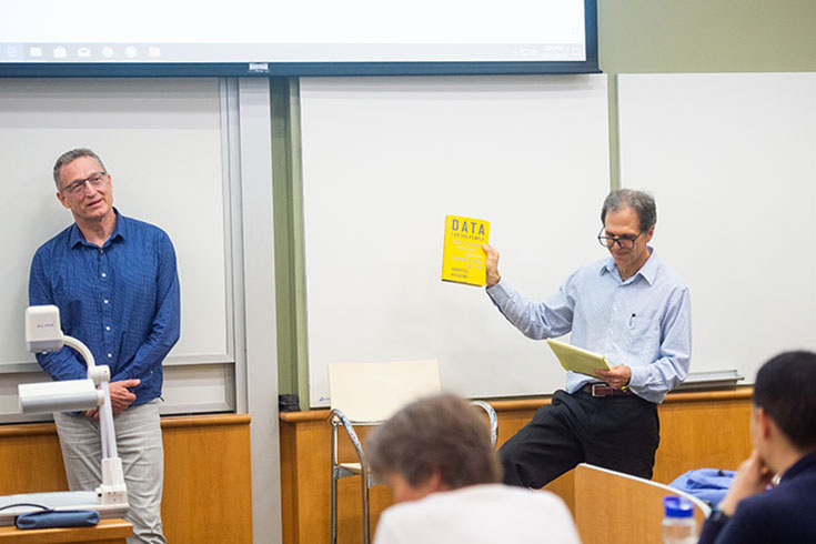 man showing book to classroom