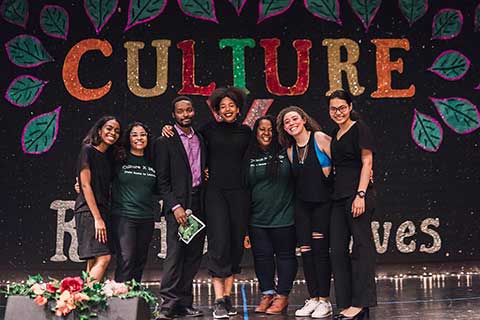 Students and ICC staff hug in front of the Culture X sign
