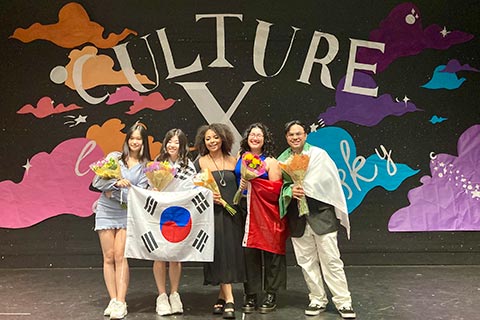 Culture X planning group poses on the stage