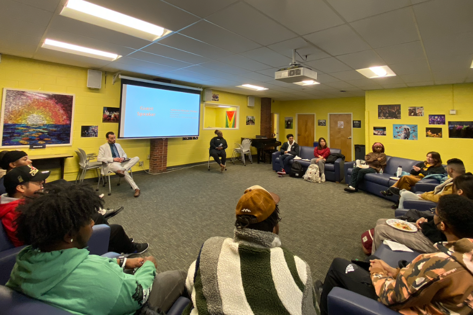 Guest speaker, attendees are in a circle.