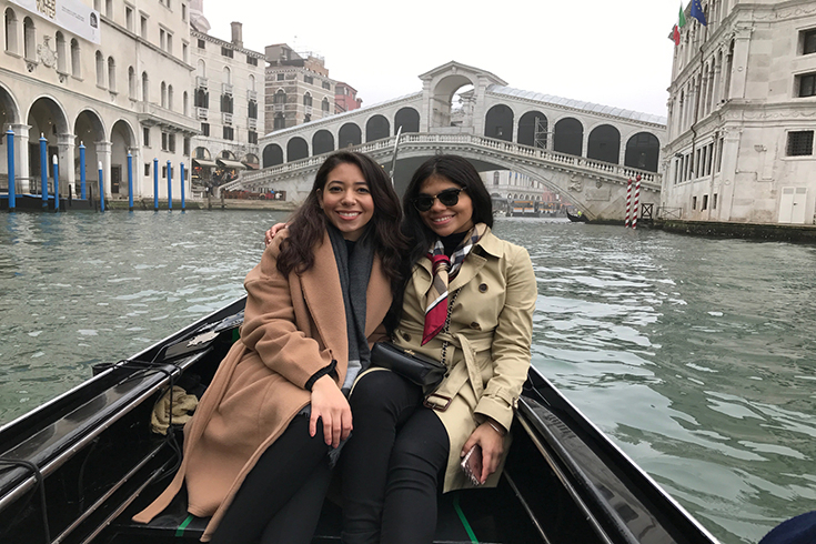 Two students sitting on a gondola in Italy