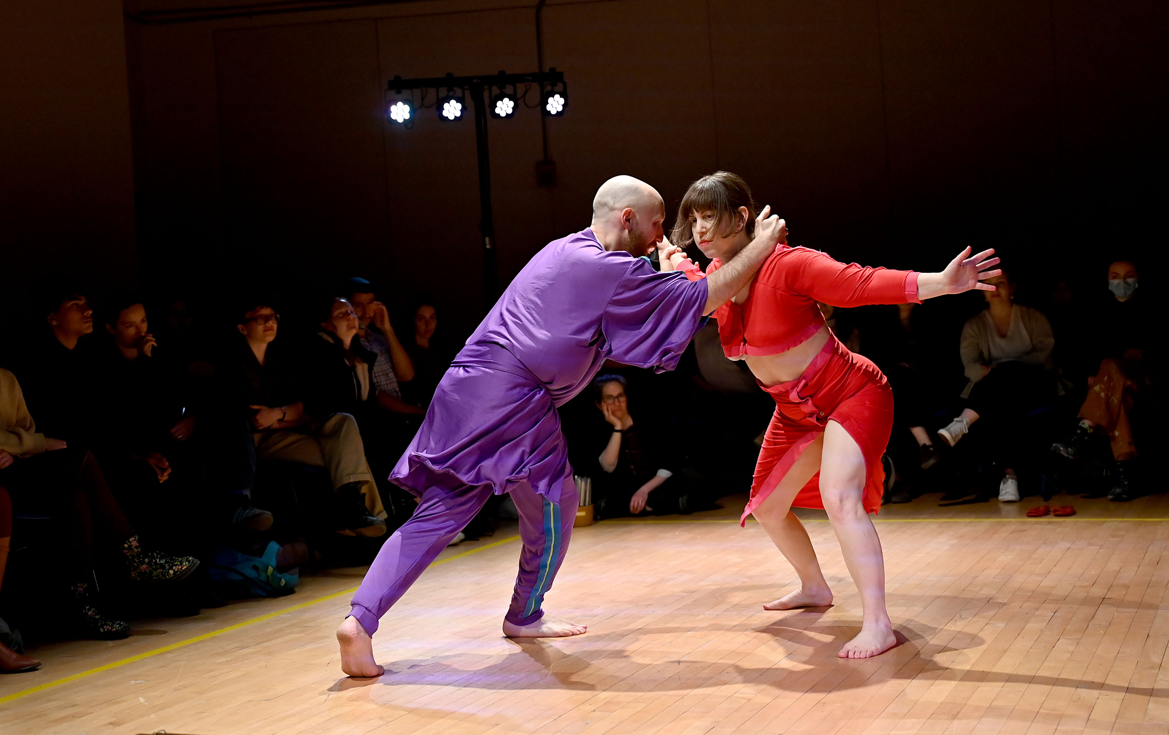 Dance piece where one actor is wearing purple and the other is wearing red