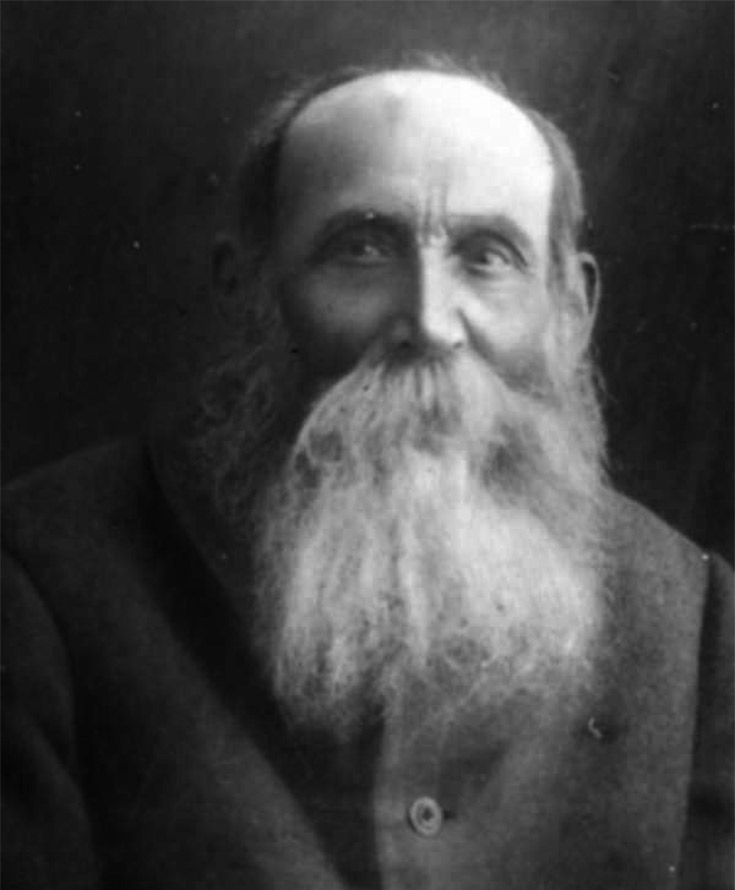 Old sepia-tone photo of an older man with a long, white beard