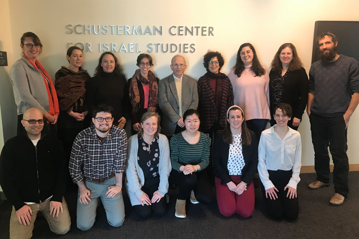 Group of graduate students posed in two rows with Jonathan Sarna and Yael Zeruabvel, assembled in front of a wall with a sign reading Schusterman Center for Israel Studies