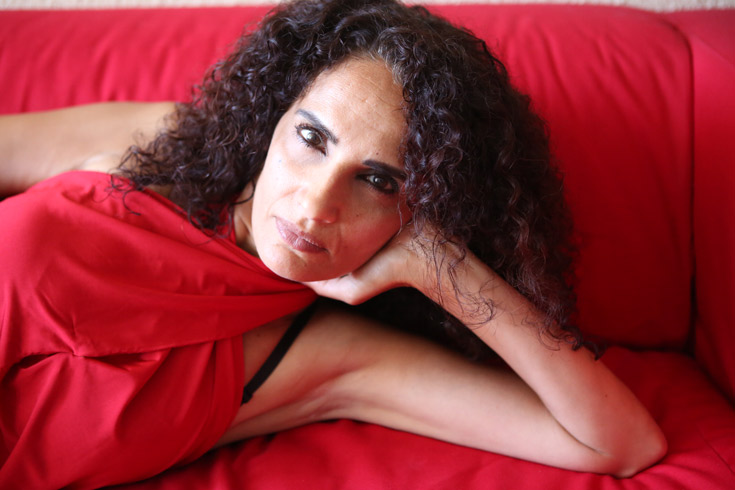 Woman in red with dark, curly hair