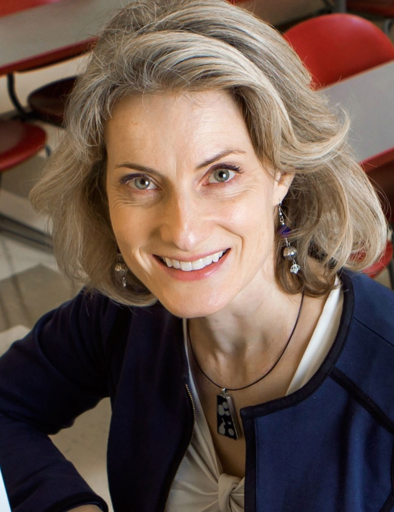 Close-up portrait of elegantly-dressed woman with shoulder length blonde hair.