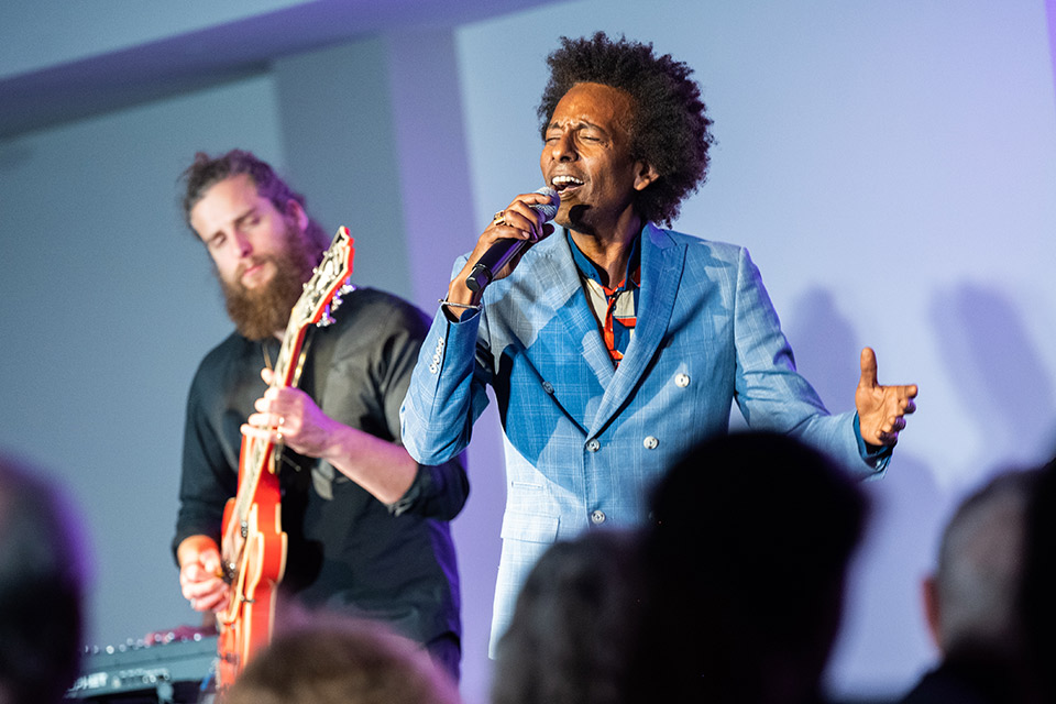 Man singing passionately into a microphone and a man playing guitar