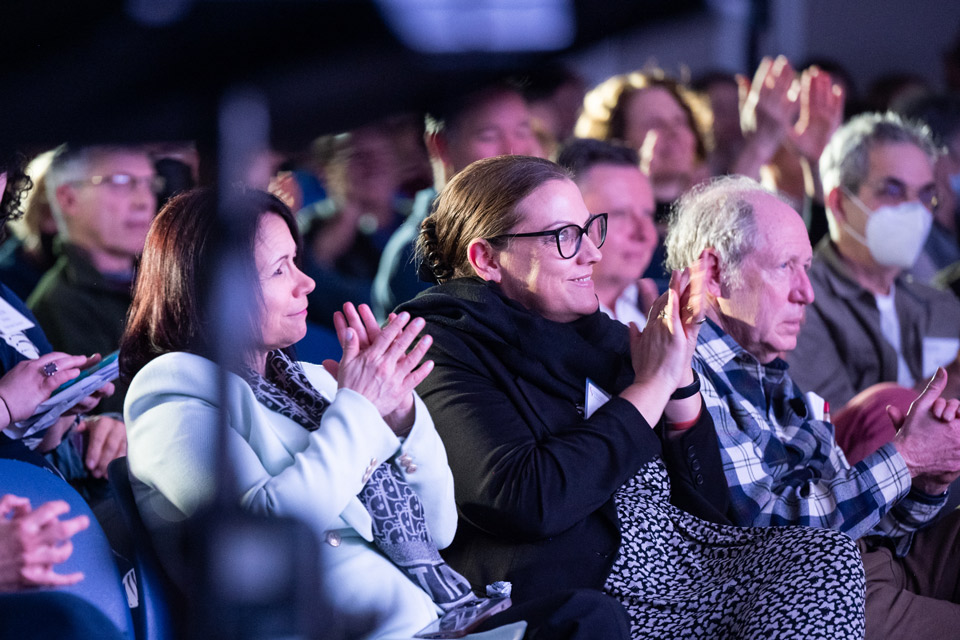 People seated smiling and clapping