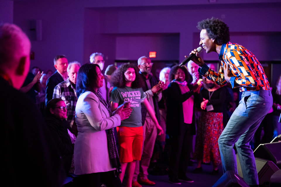 Man singing to a standing audience 