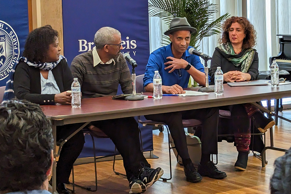 Four people seated at a table with microphones