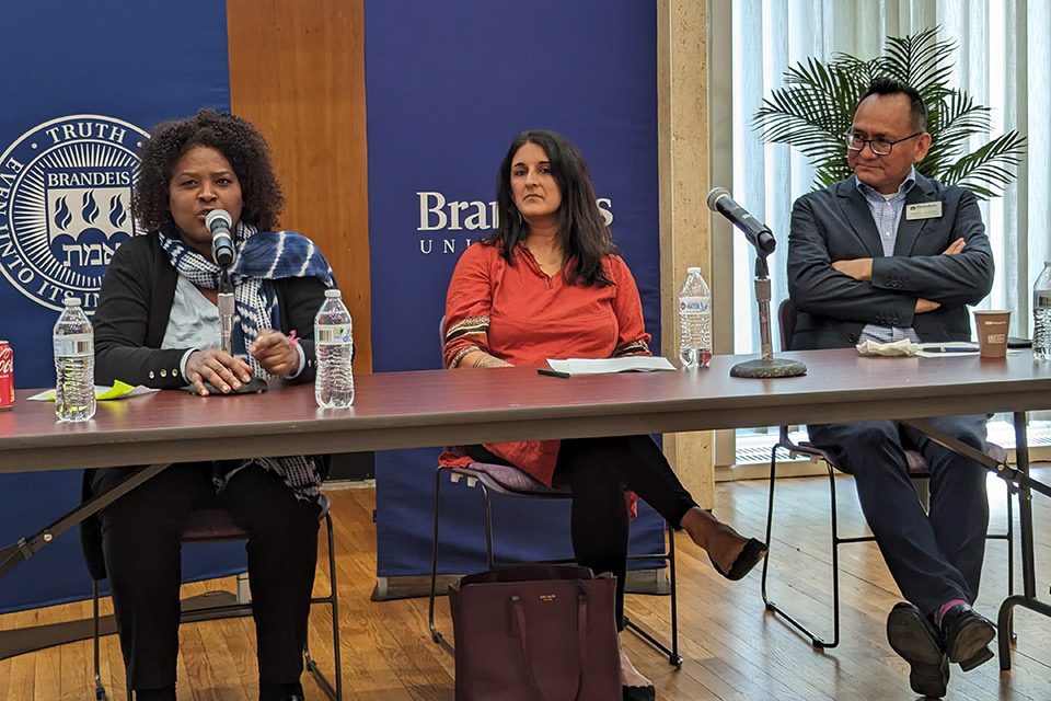 Three people seated at a table with microphones