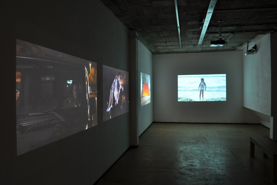 Film screens in a darkened exhibition space