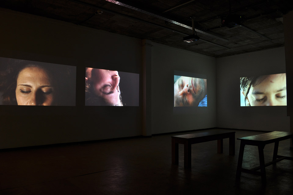 Film screens in a darkened exhibition space