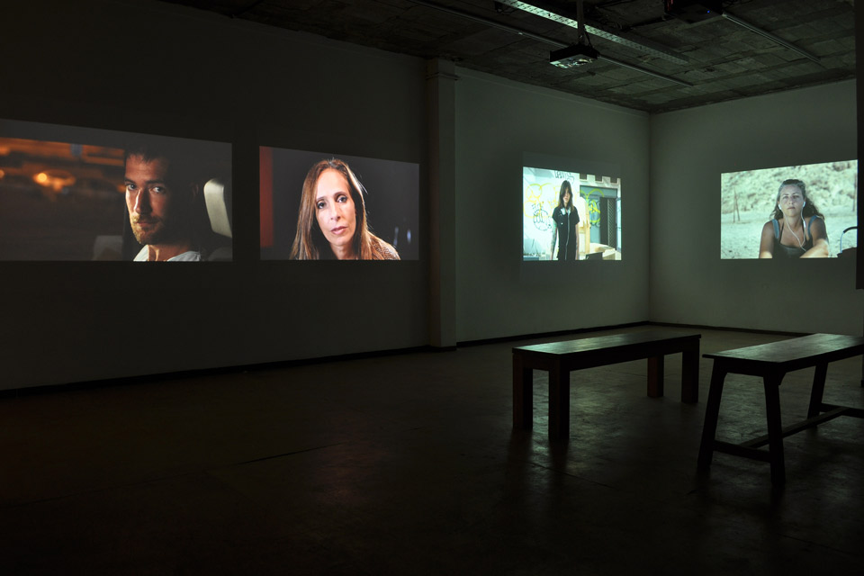 Film screens in a darkened exhibition space