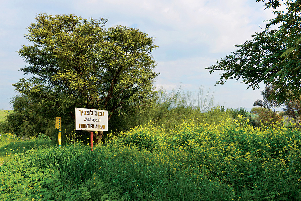 Sign saying "Frontier ahead" in Hebrew, Arabic and English