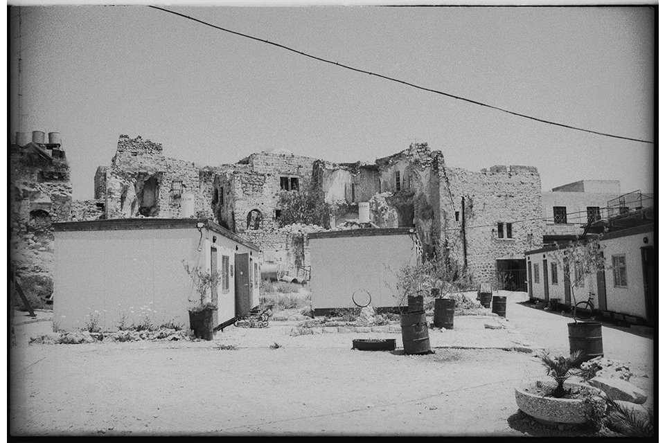 Small, new buildings with ruins in the background