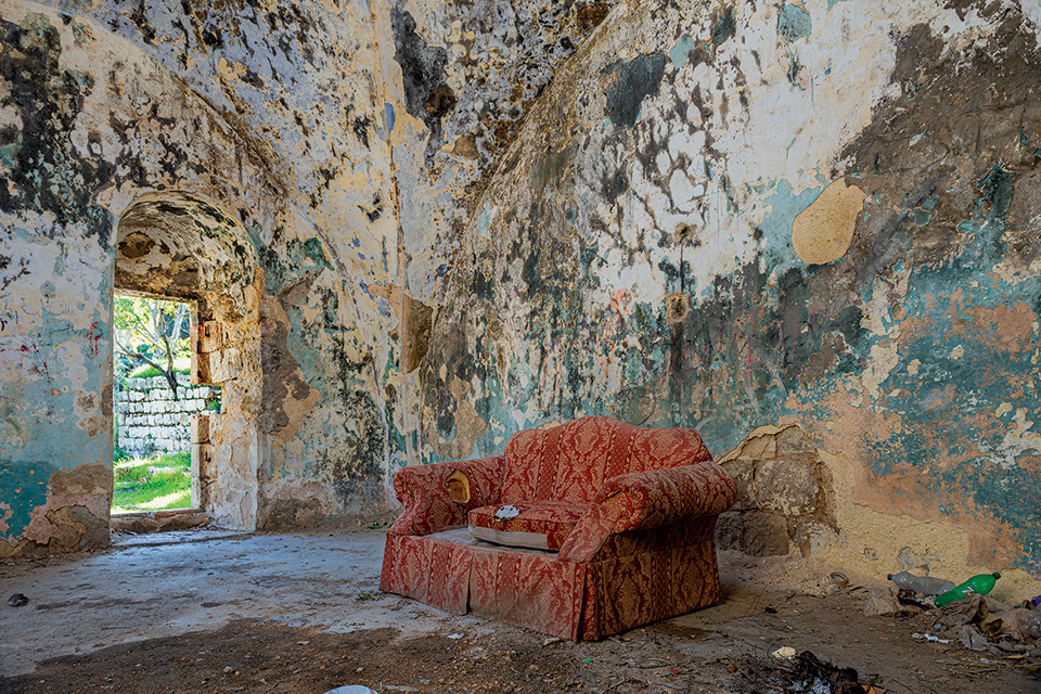 Couch in an old, abandoned, ancient-looking building