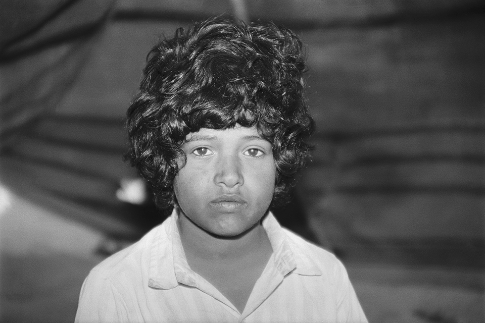 Close-up of a child's face, framed with copious dark curls