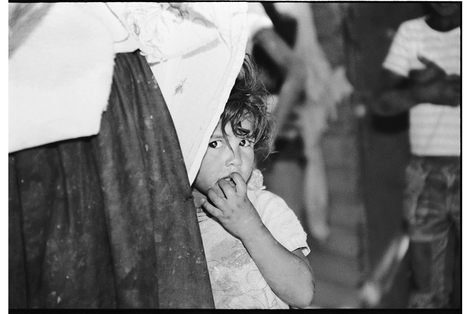 A child peeks around fabric