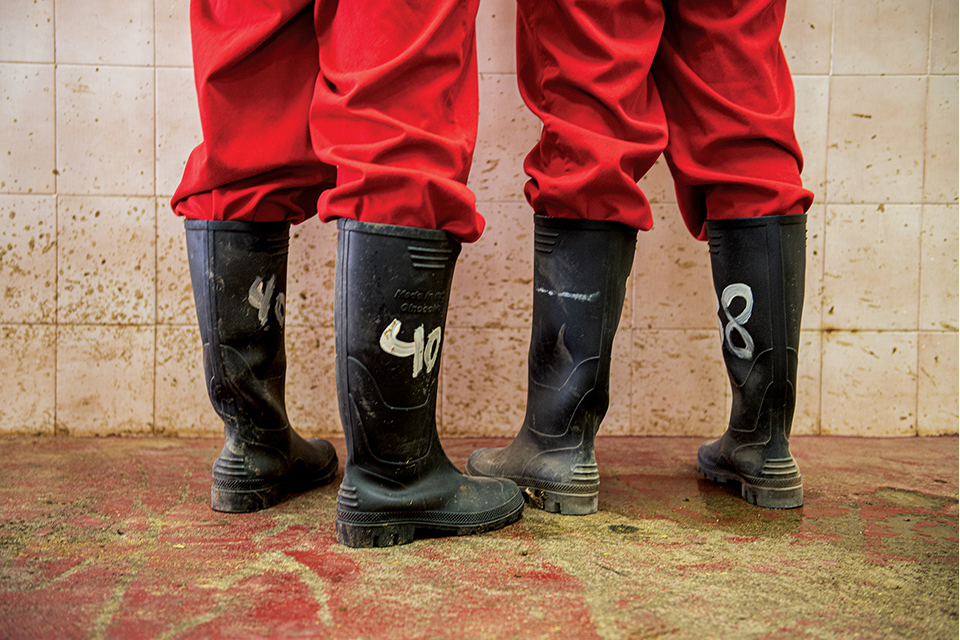 Two pairs of legs in red pants and black boots