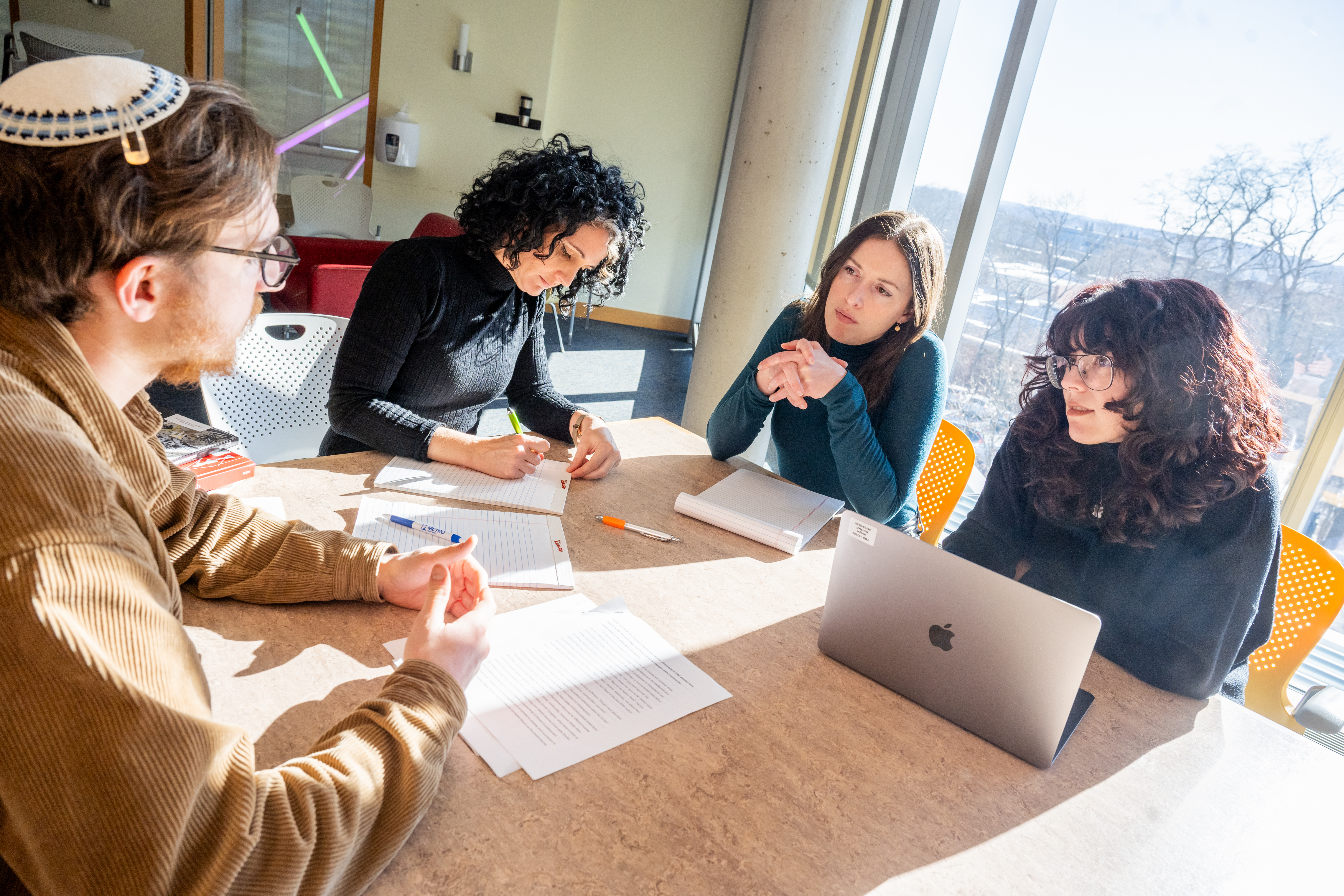 Doctoral Students have a discussion seated around a table