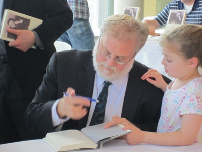Mirsky with his daughter, signing a book