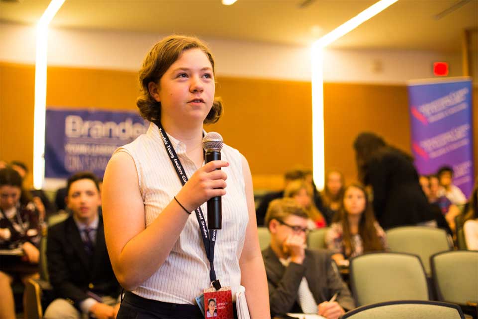 Young woman asking a speaker question on the microphone 