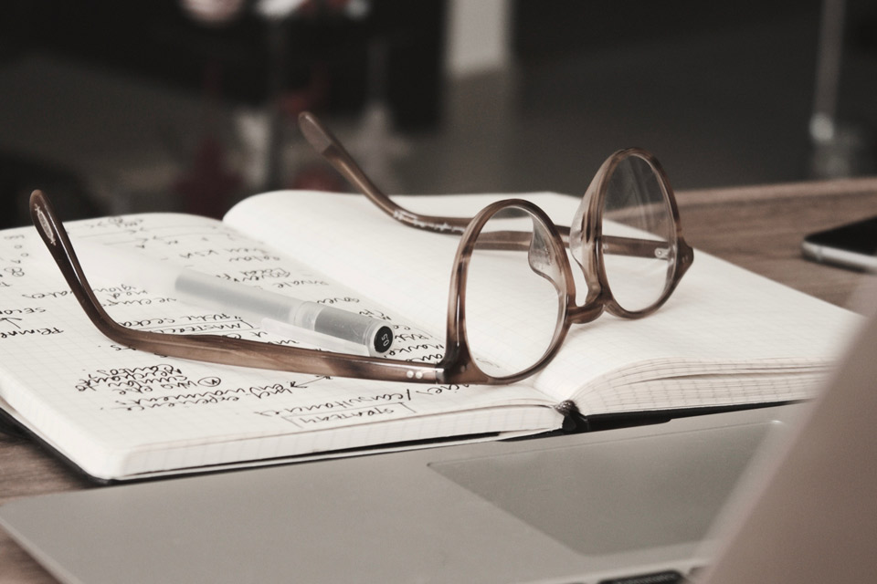 glasses with a pad, pen and laptop