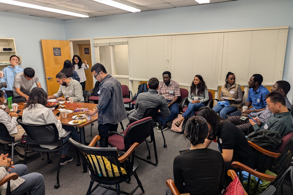 Group of people sitting around a table drinking coffee