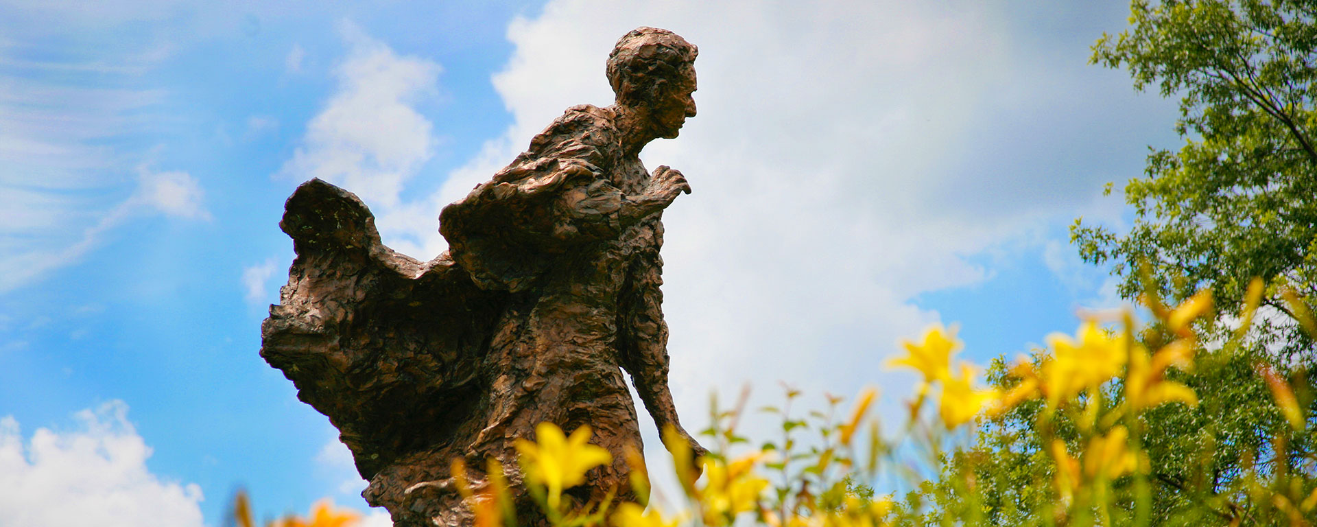 statue of justice brandeis amid field of yellow flowers