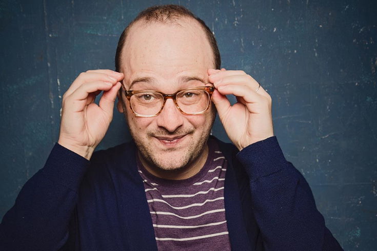 Josh Gondelman adjusting his glasses