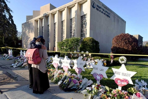 Outside the Tree of Life synagogue, flowers and markers line the sidewalk