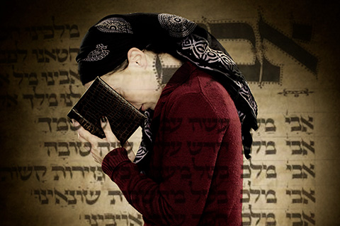 A woman praying with book and head bowed 